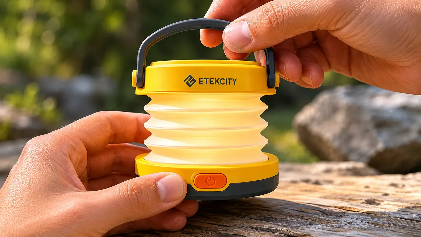 Hand pulling up the collapsible top panel of the Etekcity lantern to extend it from its collapsed flat shape