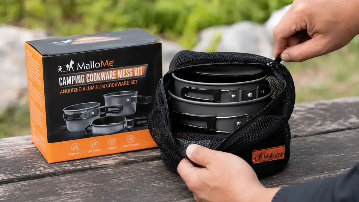 Hand opening the MalloMe camping cookware mess kit to show the nested pots, pan, and utensils inside the carry bag